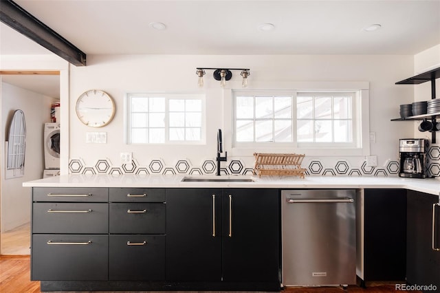 kitchen featuring dishwasher, light hardwood / wood-style floors, washer / dryer, and sink