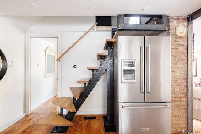 kitchen featuring stainless steel fridge with ice dispenser, light hardwood / wood-style floors, and a healthy amount of sunlight