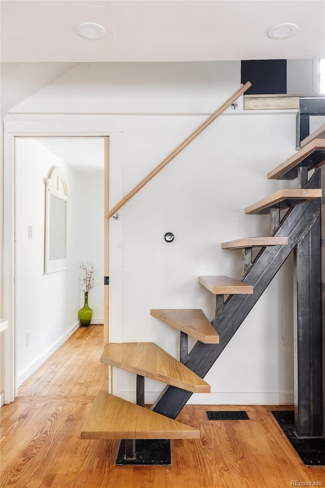 staircase with hardwood / wood-style floors