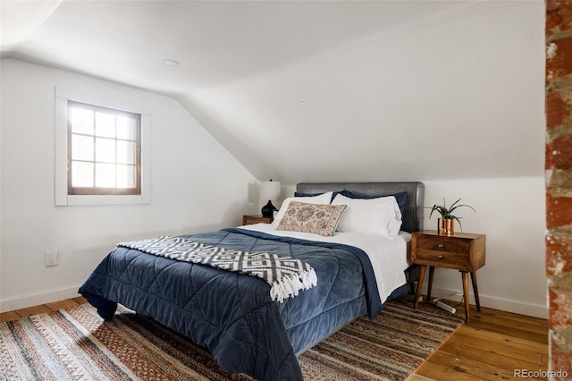 bedroom featuring hardwood / wood-style floors and vaulted ceiling