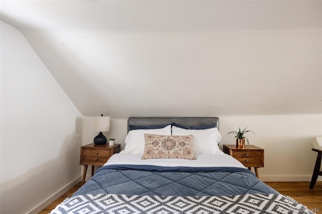 bedroom featuring wood-type flooring and vaulted ceiling