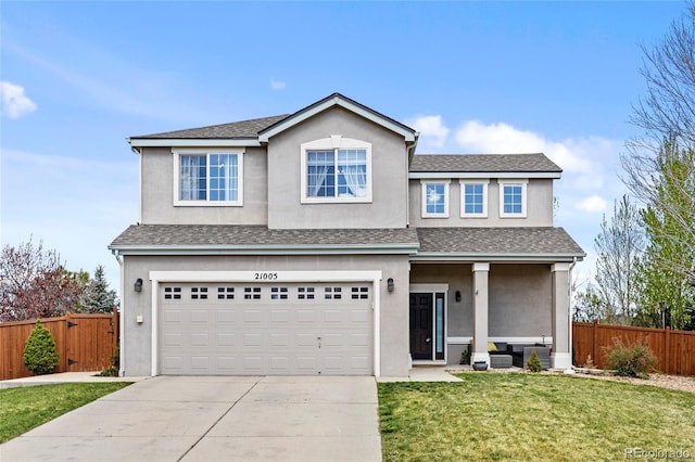 traditional home featuring fence, an attached garage, concrete driveway, and a front lawn