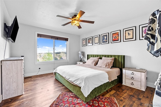 bedroom with baseboards, a ceiling fan, and dark wood-style floors
