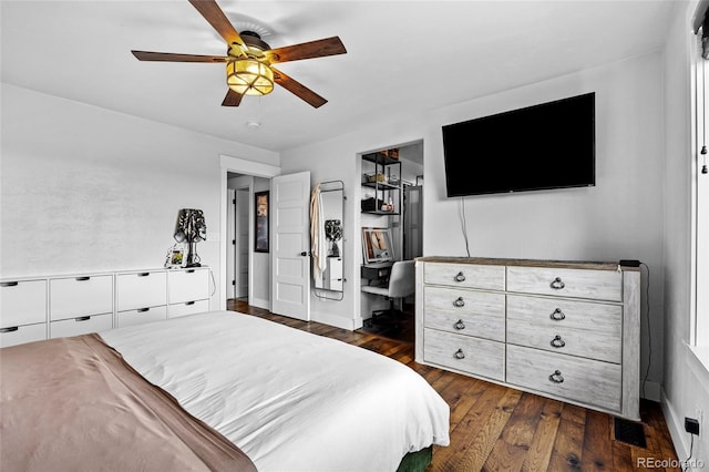bedroom with ceiling fan, visible vents, a closet, a spacious closet, and dark wood-type flooring