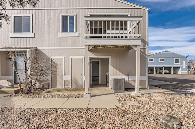 back of property featuring a balcony and central AC unit