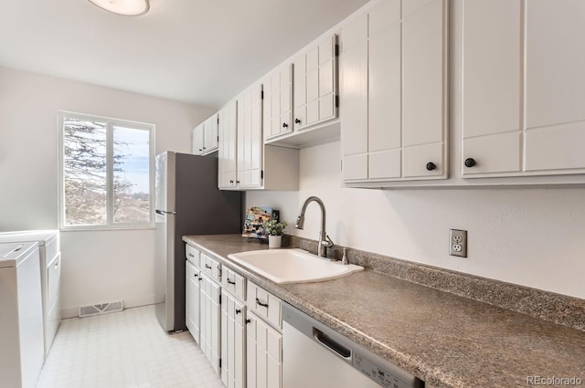 kitchen featuring white cabinetry, independent washer and dryer, stainless steel appliances, and sink