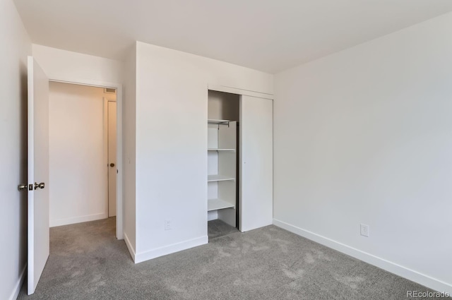 unfurnished bedroom with light colored carpet and a closet