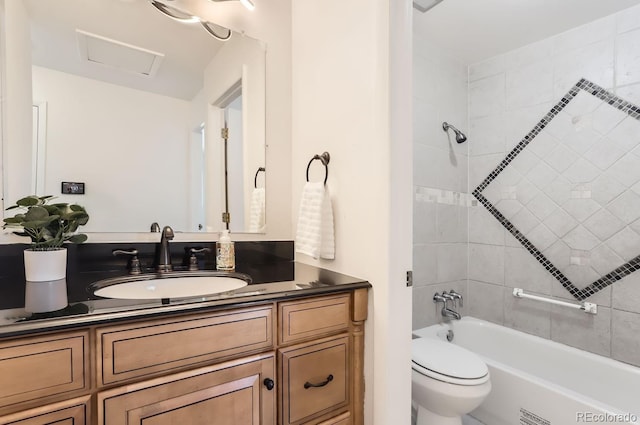 full bathroom featuring vanity, tiled shower / bath combo, and toilet