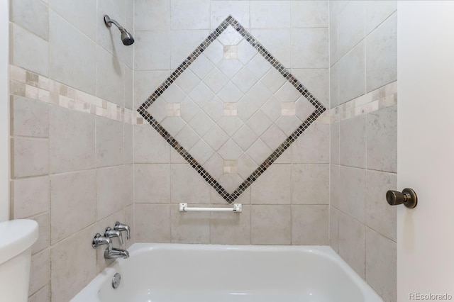 bathroom with tiled shower / bath combo and toilet