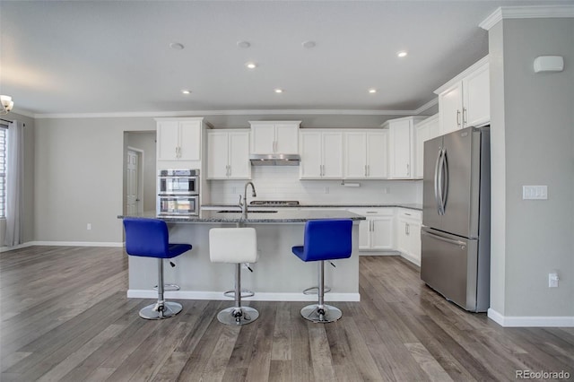 kitchen with a kitchen island with sink, white cabinetry, and stainless steel appliances