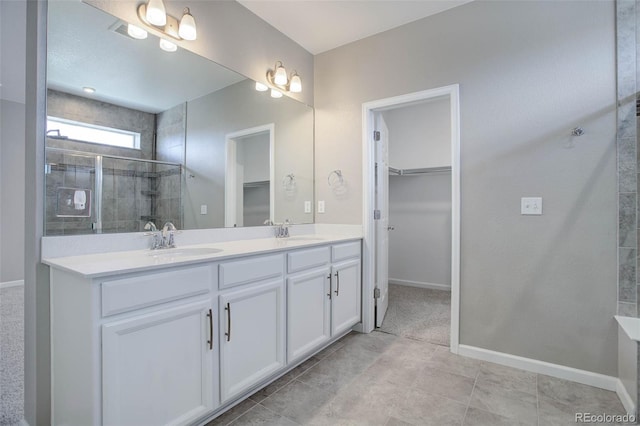 bathroom with an enclosed shower, vanity, and tile patterned flooring