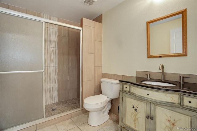 bathroom with tile walls, tile patterned flooring, vanity, walk in shower, and toilet