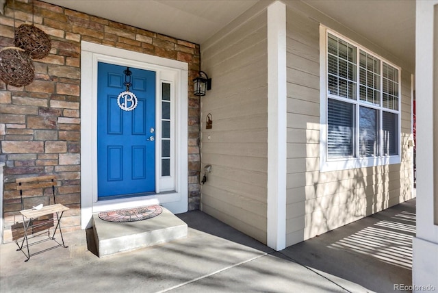 entrance to property with stone siding and covered porch