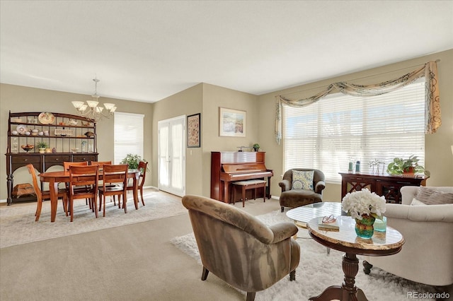 living area with a notable chandelier, baseboards, carpet, and a healthy amount of sunlight