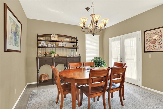 carpeted dining space with an inviting chandelier and baseboards