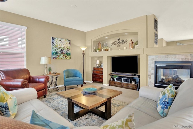 carpeted living room featuring a fireplace and baseboards