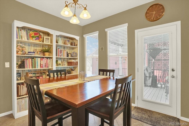 dining room featuring light tile patterned floors, baseboards, and a chandelier