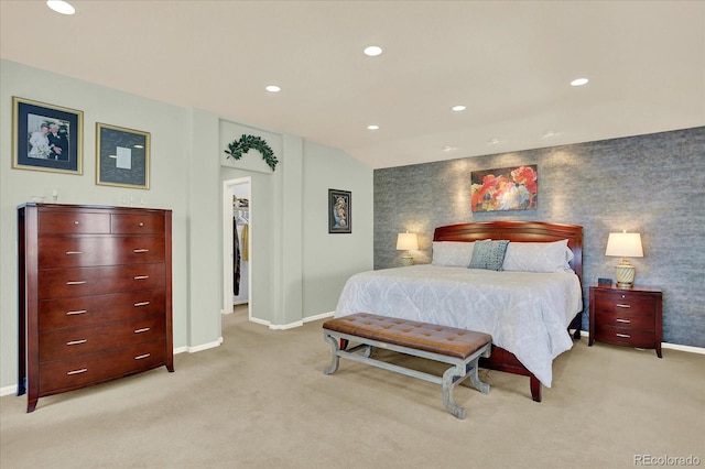 bedroom with an accent wall, recessed lighting, light colored carpet, and baseboards