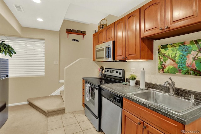 kitchen with dark countertops, visible vents, stainless steel appliances, and a sink