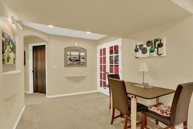 dining space featuring recessed lighting, arched walkways, baseboards, and light carpet