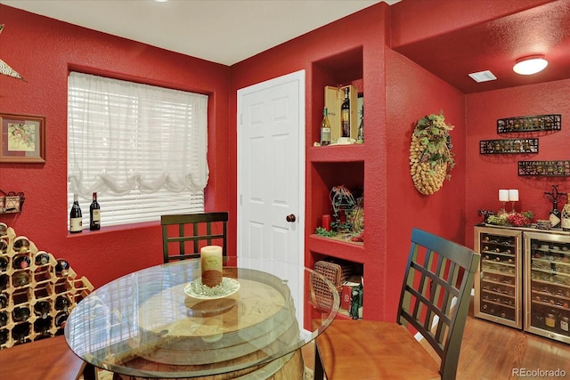 dining area featuring visible vents, wood finished floors, and a textured wall