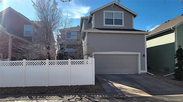 traditional-style home with a garage, driveway, and fence