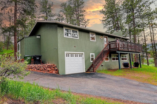 5237 S Olive Rd, Evergreen, CO 80439 - view of front facade with a deck, stairs, a garage, driveway, and a chimney
