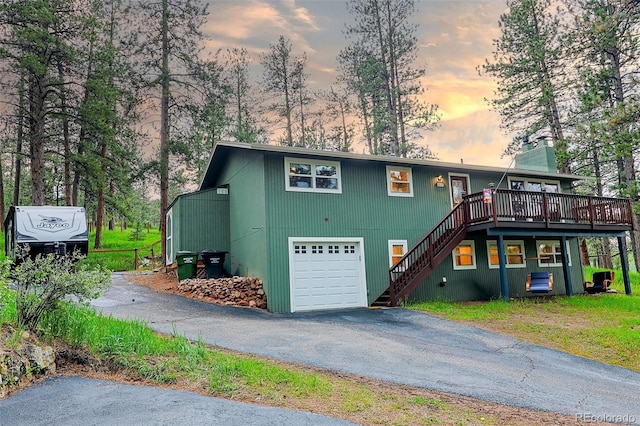 5237 S Olive Rd, Evergreen, CO 80439 - view of front of property featuring stairs, a wooden deck, driveway, a garage, and a chimney