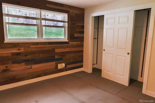 5237 S Olive Rd, Evergreen, CO 80439 - unfurnished bedroom with dark carpet, wooden walls, a closet, and baseboards