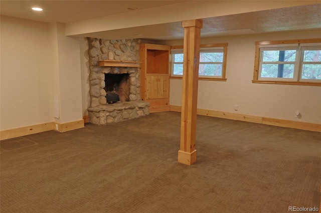 5237 S Olive Rd, Evergreen, CO 80439 - basement with dark carpet, baseboards, and a stone fireplace