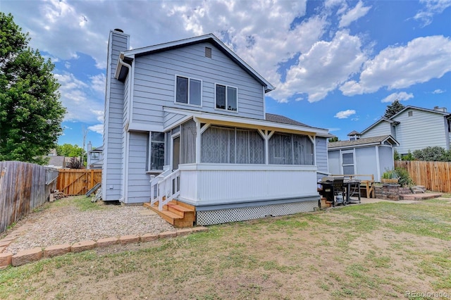 6034 S Parfet St, Littleton, CO 80127 - rear view of property with a chimney, a fenced backyard, and a sunroom