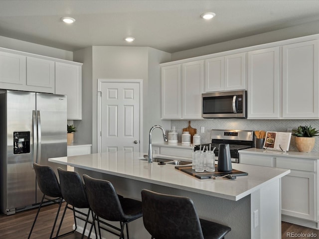 kitchen featuring sink, a kitchen island with sink, dark wood-type flooring, appliances with stainless steel finishes, and white cabinets