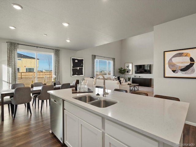 kitchen featuring white cabinetry, an island with sink, dark hardwood / wood-style flooring, dishwasher, and sink