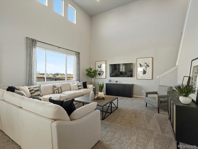 living room with a high ceiling and light colored carpet