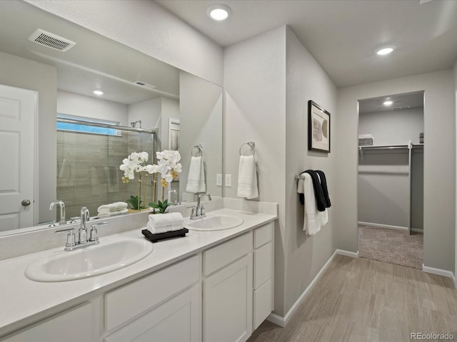 bathroom with vanity, hardwood / wood-style floors, and a shower with door