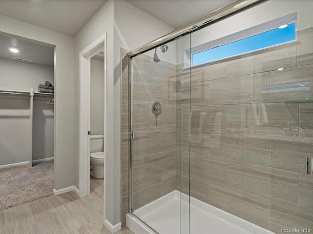 bathroom featuring toilet and an enclosed shower