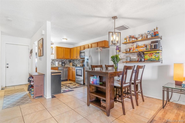 2279 Coronado Pkwy Unit B, Denver, CO 80229 - dining room featuring a textured ceiling, light tile patterned floors, and visible vents