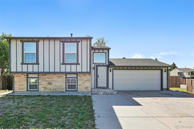 5202 Dillon St, Denver, CO 80239 - split level home featuring board and batten siding, fence, driveway, an attached garage, and brick siding