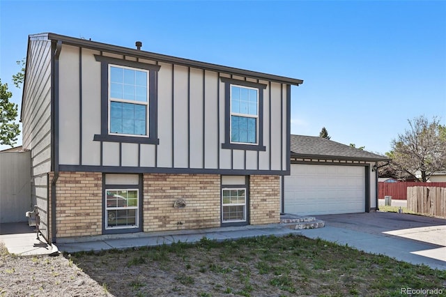 5202 Dillon St, Denver, CO 80239 - view of front of property with driveway, board and batten siding, fence, brick siding, and a garage