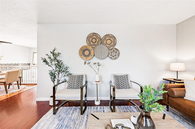 5202 Dillon St, Denver, CO 80239 - living area featuring a textured ceiling, wood finished floors, and baseboards
