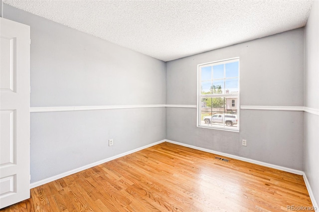 5202 Dillon St, Denver, CO 80239 - spare room with wood finished floors, baseboards, and a textured ceiling