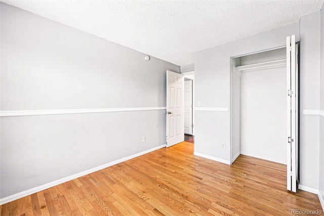 5202 Dillon St, Denver, CO 80239 - unfurnished bedroom featuring light wood-style flooring, a textured ceiling, and baseboards