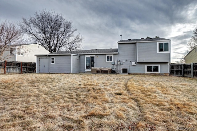 back of house featuring central AC unit, a yard, and outdoor lounge area