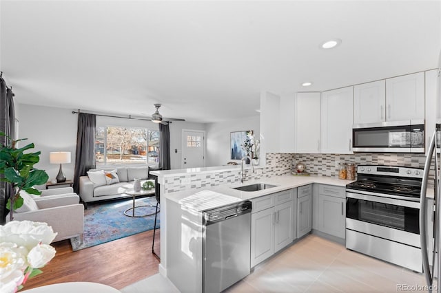 kitchen featuring stainless steel appliances, sink, ceiling fan, kitchen peninsula, and gray cabinets