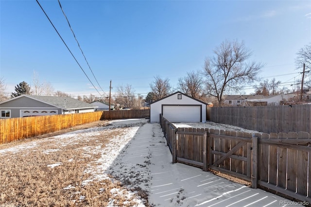 snowy yard with an outbuilding and a garage