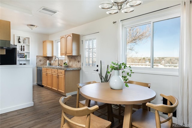 dining area with dark hardwood / wood-style flooring, sink, and a notable chandelier