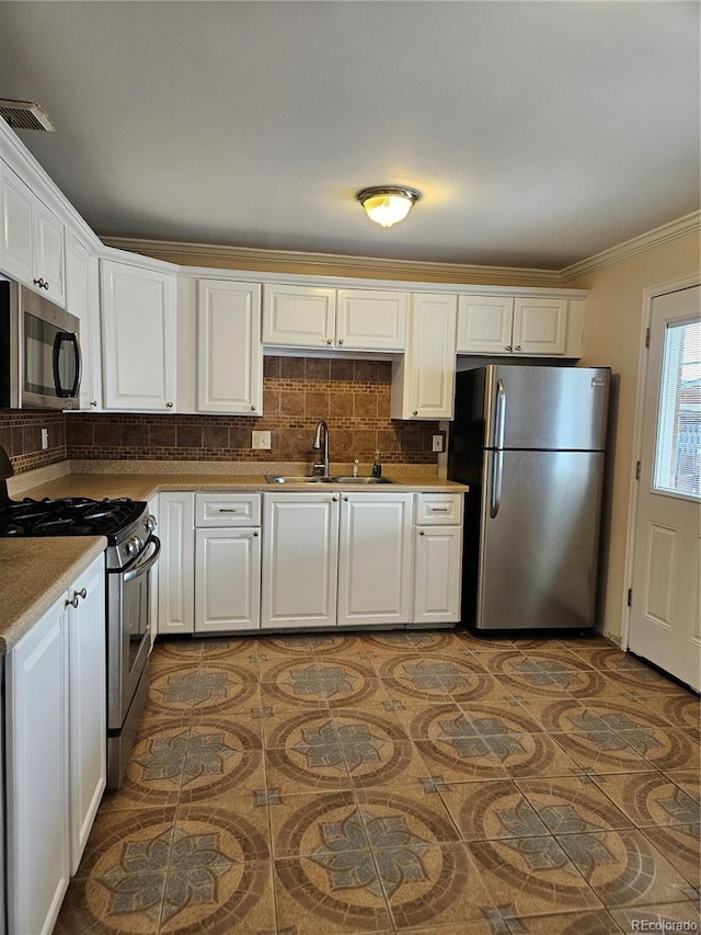 kitchen featuring white cabinetry, appliances with stainless steel finishes, sink, and backsplash