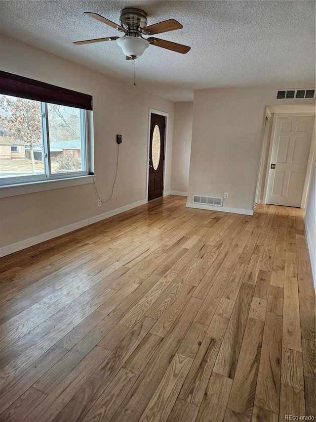 interior space with ceiling fan, light hardwood / wood-style floors, and a textured ceiling