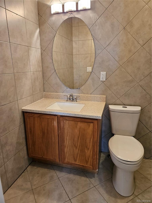 bathroom featuring vanity, tile walls, tile patterned floors, and toilet