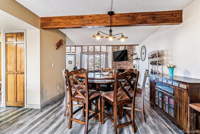 dining space with dark wood-type flooring, a textured ceiling, and beamed ceiling